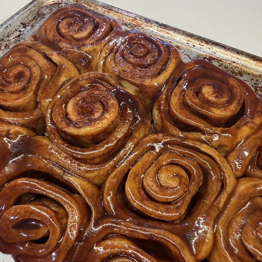 A pan of glazed cinnamon rolls, fresh out of the oven